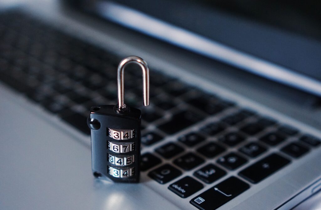 A picture of an unlocked padlock on top of a laptop keyboard.