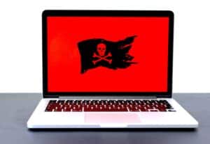 Picture of a skull and cross bones on a black flag on a laptopn screen.